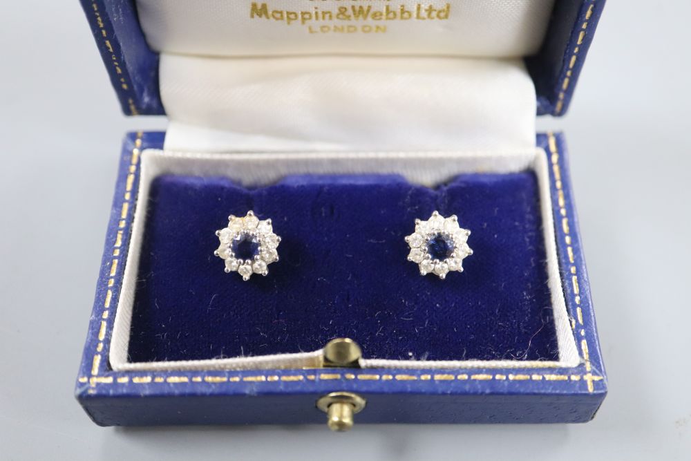 A modern pair of 18ct white gold, sapphire and diamond set circular cluster rings, 9mm, gross 3.2 grams.